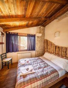 a bedroom with a bed and a wooden ceiling at Locanda del Silenzio Hotel in Macra