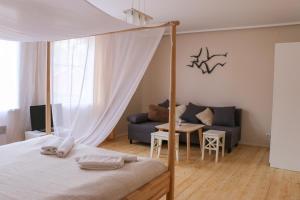 奈达夏日旅馆的一间卧室，里面有一张床、一张沙发和一张桌子