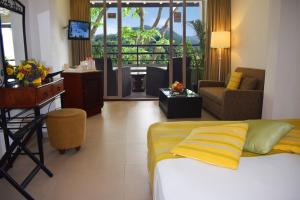 Habitación de hotel con cama y sala de estar. en Thilanka Hotel, en Kandy