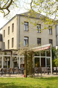 a building with tables and chairs in front of a building at Hotel Restaurant Le Paris in Mondorf-les-Bains