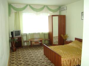 a bedroom with a bed and a table and a window at Отель ИРОН 1 in Krasnodar