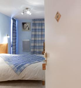 a bedroom with a bed and a blue wall at Hôtel Restaurant Les Alpins in Saint-Julien-en-Beauchêne