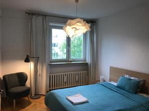 a bedroom with a bed and a chair and a window at Wilson Apartment in Warsaw