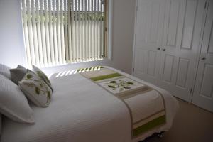 een bed in een kamer met een raam bij Oasis on Marsh in Armidale