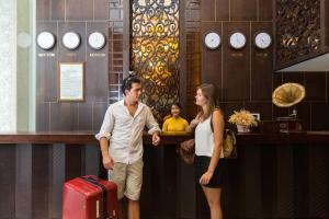 a man and a woman standing at a bar with a child at Palazzo Luxury Hotel in Da Nang