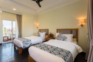 Postel nebo postele na pokoji v ubytování Grand Bayon Siem Reap Hotel