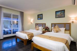 Postel nebo postele na pokoji v ubytování Grand Bayon Siem Reap Hotel