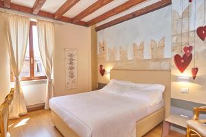 1 dormitorio con 1 cama y una pintura de corazones en la pared en Le Suite Di Giulietta, en Verona