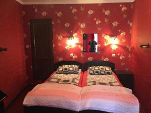1 dormitorio con cama y pared roja en Hotel Formula-1, en Tiflis