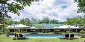 um resort com piscina, cadeiras e guarda-sóis em Perry's Bridge Hollow Boutique Hotel em Hazyview