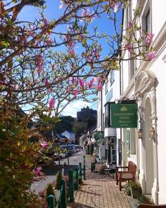 una strada in una città con fiori rosa di Yarn Market Hotel a Dunster