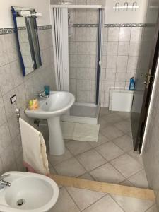 uma casa de banho com um lavatório, um chuveiro e um WC. em Affittacamere Peonia em Oliena