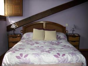 Una cama con dos almohadas encima. en Casa Alval, en Villacastín