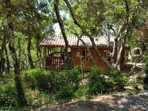 a log cabin in the woods with trees at Camping Ibie in Lagorce