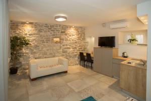 a living room with a white couch and a kitchen at Situs Residence in Split