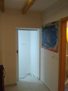 a room with a white door and a painting on the wall at Apartment Ribno in Bled