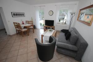 ein Wohnzimmer mit einem Sofa, einem Stuhl und einem Tisch in der Unterkunft Ferienwohnung Konen in Sankt Aldegund