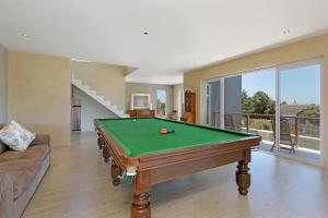 Una sala de estar con una mesa de billar y un sofá. en Greenways Drive Apartment, en Kommetjie