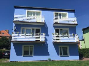 un edificio azul con gente en los balcones en Bosmanska 11, en Darłówko