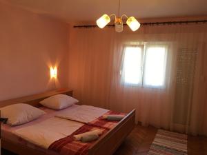 Un dormitorio con una cama con dos almohadas y una ventana. en Apartment Damir, en Senj