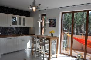 a kitchen with a table and chairs and a balcony at Apartamenty Flaming Baltic Park Stegna in Stegna