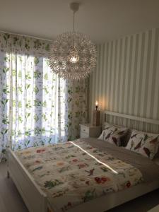 um quarto com uma cama grande e um lustre em Apartamenty Flaming Baltic Park Stegna em Stegna