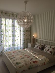 a bedroom with a large bed and a chandelier at Apartamenty Flaming Baltic Park Stegna in Stegna