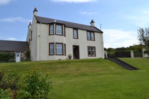 una gran casa blanca con un gran patio en Burnside Farm B & B en Girvan