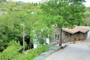 una pequeña casa de piedra en medio de un bosque en Moinho da Ponte Velha, en Bragança