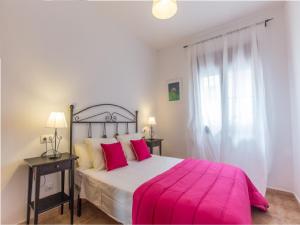 a bedroom with a large bed with a pink blanket at La Casa Del Polo- Alltarifa in Tarifa