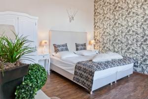 Un dormitorio con una cama blanca y una planta en Arthotel ANA Residence Bremen en Bremen