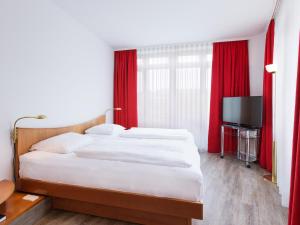 TV a/nebo společenská místnost v ubytování DORMERO Hotel Dresden Airport