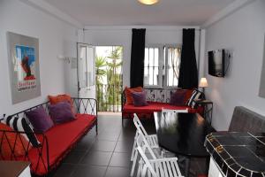 a living room with red couches and a balcony at Triplex T3 SOUTH APARTMENT in Tarifa