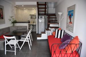 a living room with a red couch and a table and chairs at Triplex T3 SOUTH APARTMENT in Tarifa