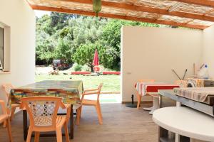 a dining room with a table and chairs and a yard at Horta do Vale - Nature House in Odeceixe