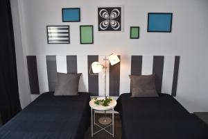 a bedroom with two beds and a table with a lamp at Triplex T3 SOUTH APARTMENT in Tarifa