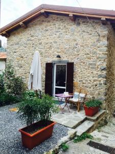 een stenen huis met een tafel en een patio bij Casa Bel in Pescaglia