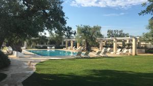 una piscina con tumbonas en un patio en Masseria Torre Del Diamante, en Torre Canne