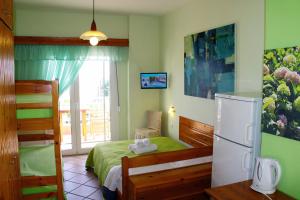 a bedroom with a bed and a refrigerator at Fasoli Studios in Paralia Panteleimonos