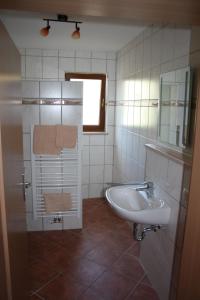 a bathroom with a sink and a bath tub at Landgasthof Haagen in Schwabhausen bei Dachau