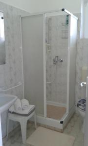 een witte badkamer met een douche en een toilet bij Guest House Surina App Surina's Green Holiday in Rupa