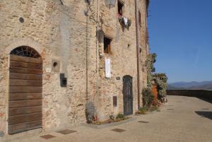 un edificio de piedra con una puerta a un lado en La Doccia, en Anghiari