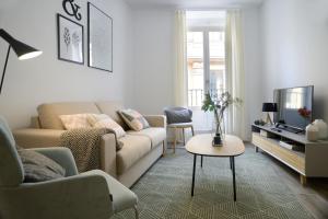 a living room filled with furniture and a tv at NQN Aparts & Suites in Madrid