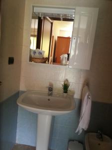 a bathroom with a sink and a mirror and a toilet at Ristoro Saint Roch in Hone
