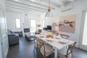 a dining room and living room with a table and chairs at THOAS Residences in Moúdhros