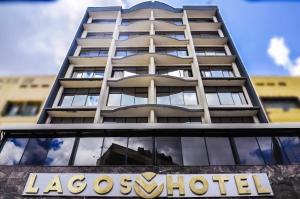 un grand bâtiment avec un panneau devant lui dans l'établissement Lagos Hotel, à Nairobi