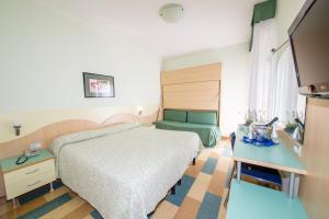 um quarto de hotel com uma cama e uma mesa em Hotel Nember em Lido di Jesolo
