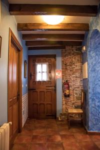 a hallway with a wooden door and a stone wall at Viviendas Rurales Las Fontanias in Cóbreces