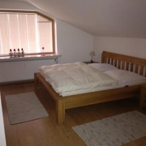 a bedroom with a large bed with a window at Ferienwohnung Hörnerblick in Fischen