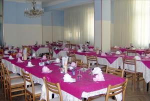 a room with pink tables and chairs with pink table cloth at Hotel Moja in Cesenatico